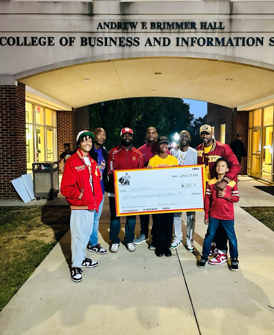 Partners of 1881 Capital Partners presenting the 2023 scholarship to Maia Triplett outside Brimmer Hall at Tuskegee University